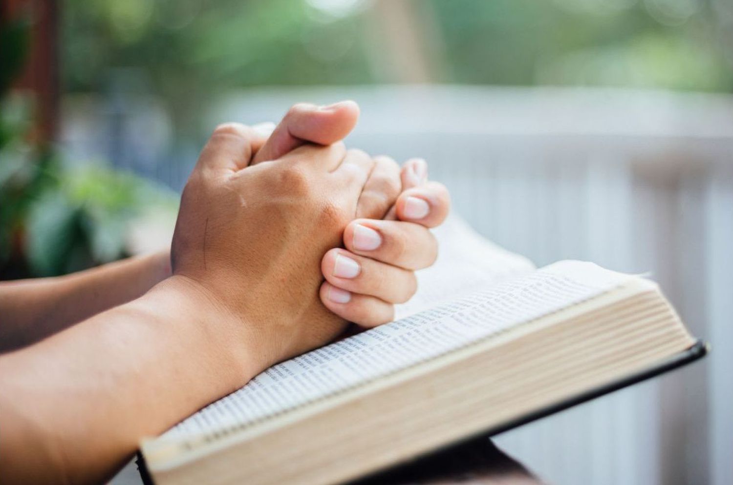kuvassa kädet yhdessä kirjan päällä