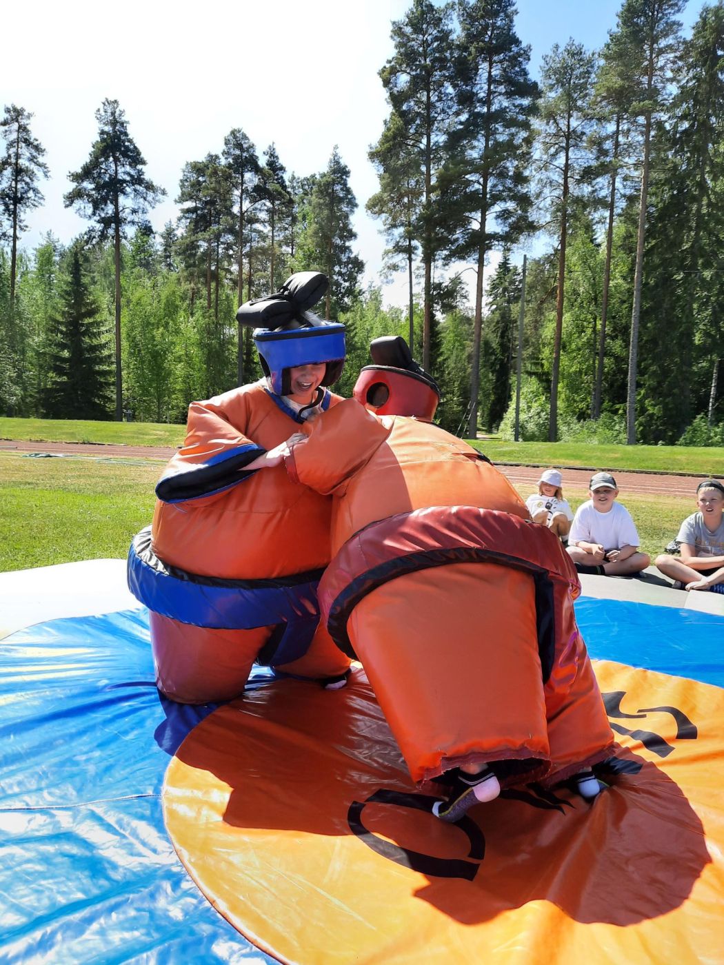 Kaksi leiriläsitä sumopainiasuissa painimassa