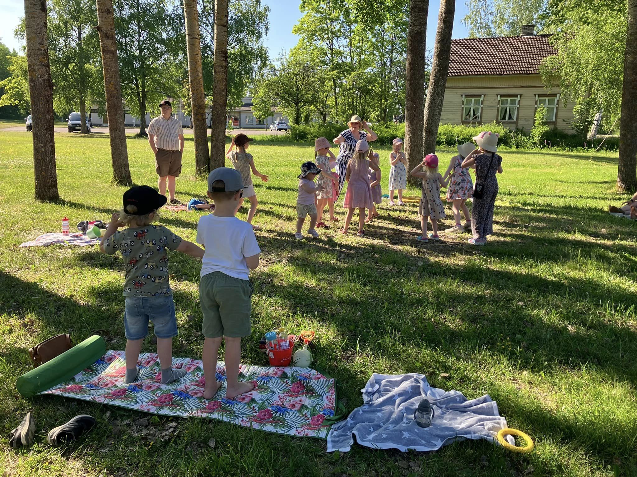 Kuvassa lasten muskari ulkona puistoalueella