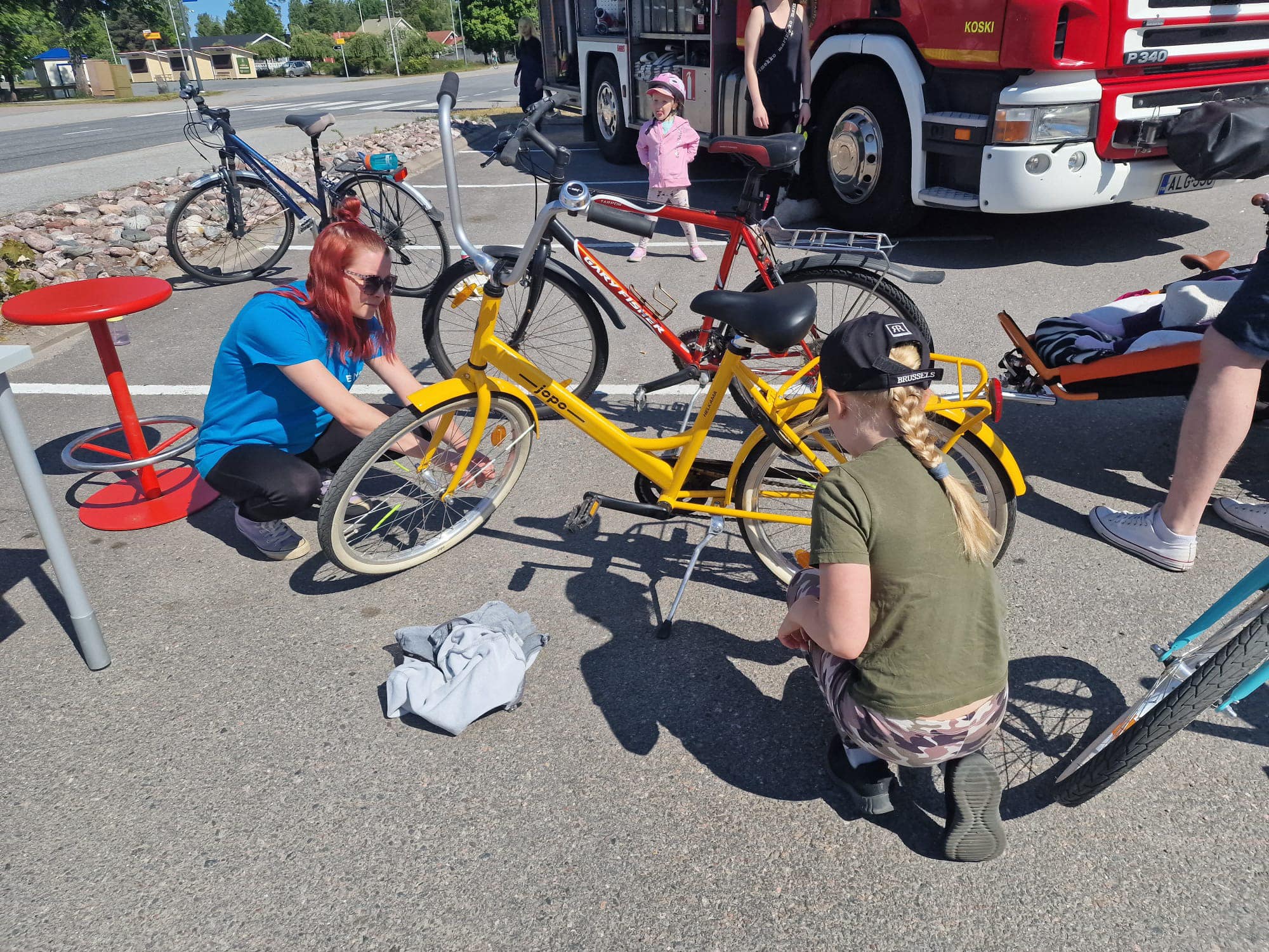 Kuvassa laitetaan keltaista polkupyörää kesäkuntoon Kosken Salen pysäköintialueella