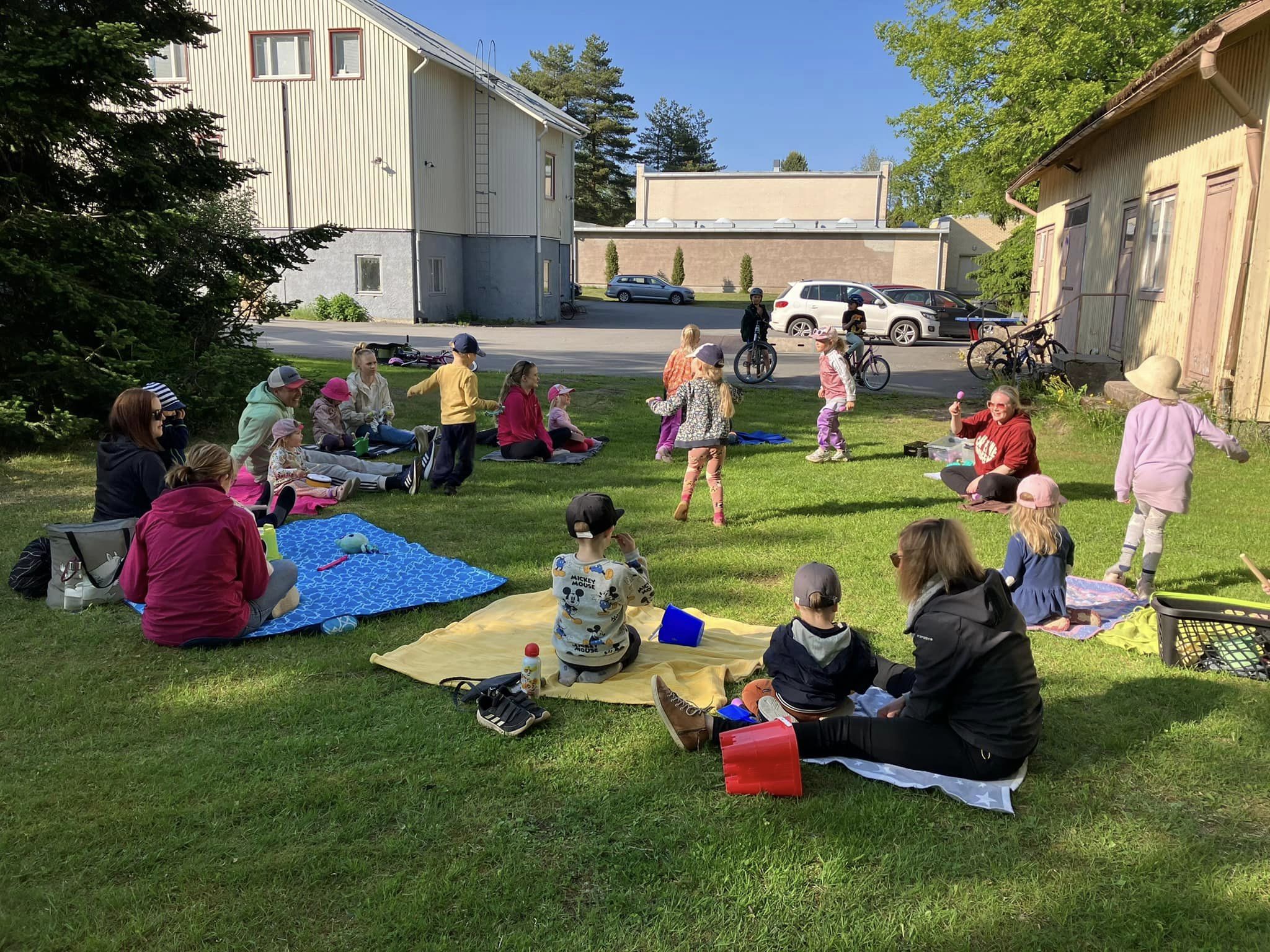 Kuvassa lasten muskari ulkona Kosken yhdistystalon vieresellä nurmikolla